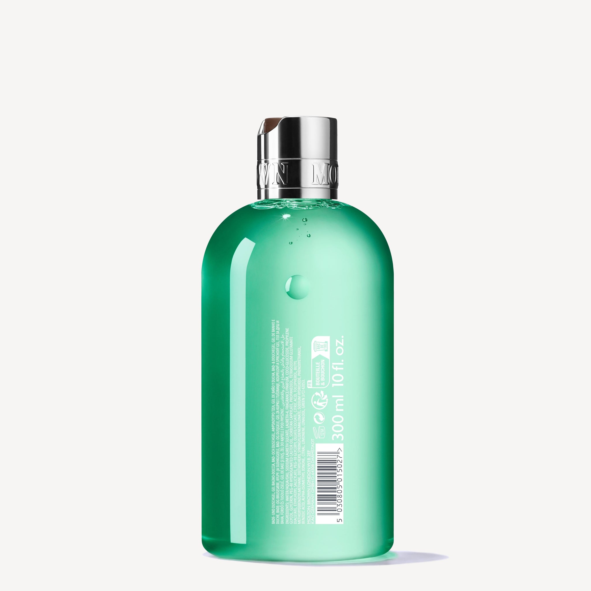 A green, transparent plastic 300ml bottle of Wild Mint & Lavandin Bath & Shower Gel with a silver cap. The label features white text, symbols, a barcode, and lists aromatic body wash on a white background.