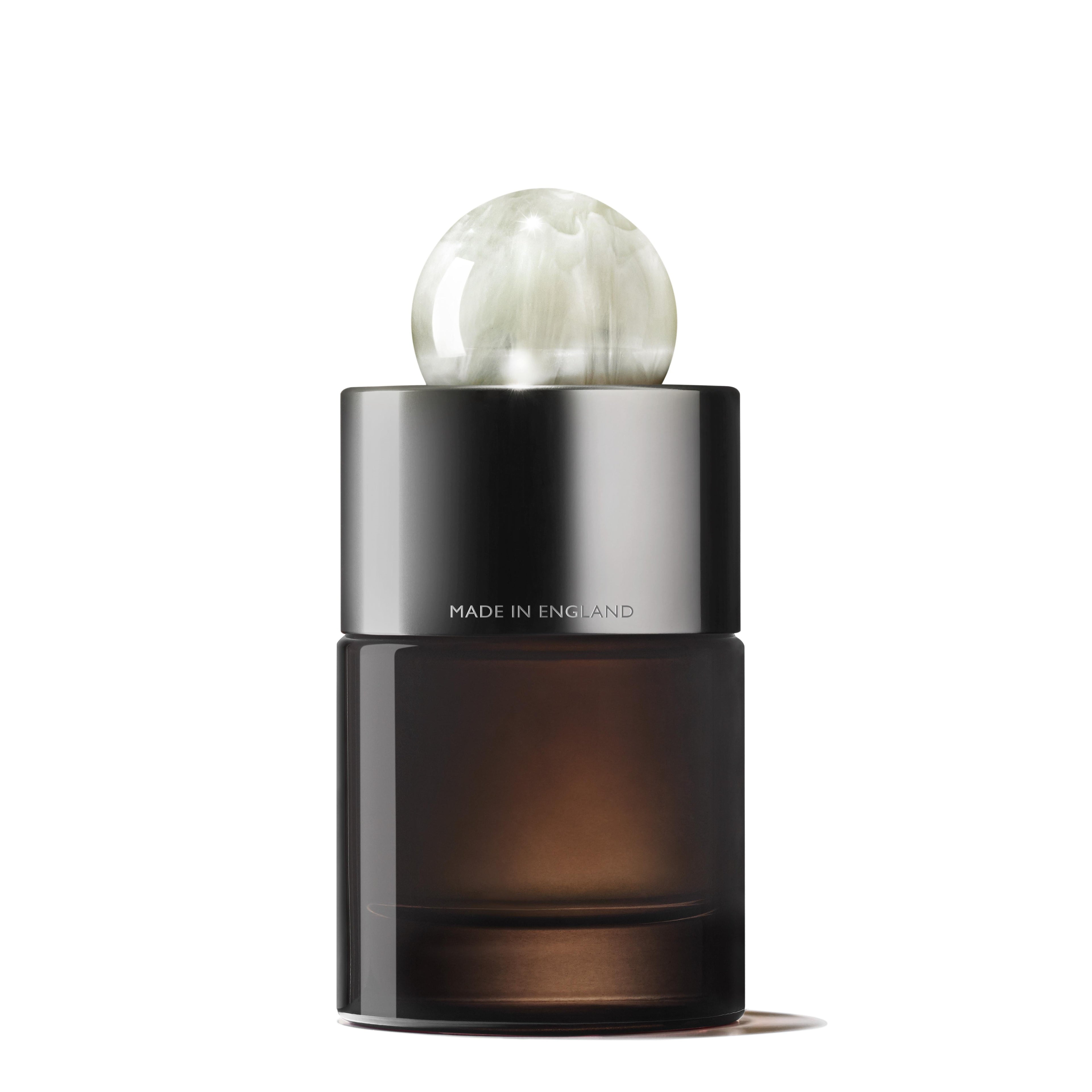 The Milk Musk Eau de Parfum 100ml comes in a dark glass bottle with a metallic cap and round marbled white topper, "MADE IN ENGLAND" on the neck, hinting at its sensual benzoin and soothing musk notes.