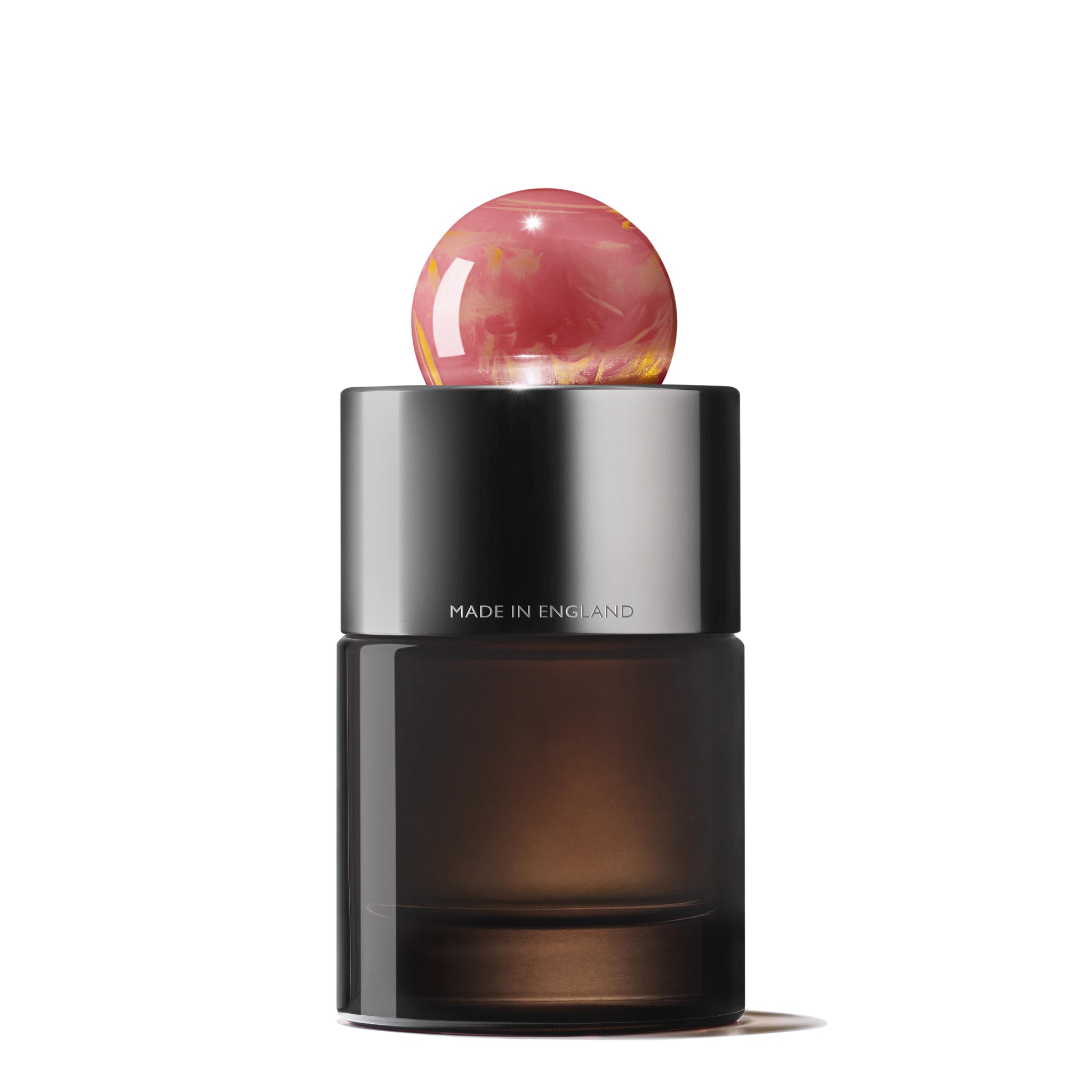 The Rose Dunes Eau de Parfum 100ml features a dark frosted bottle with a shiny metallic neck and round pink marbled cap. "MADE IN ENGLAND" is engraved on the metal band, set against a crisp white background.